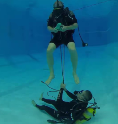 Participant wearing SCUBA gear with head-mounted display while accompanied by companion diver.