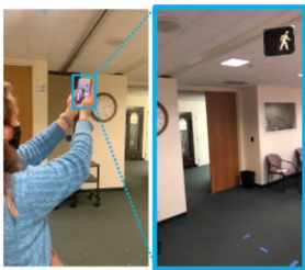 Study participant holding an iPhone in a conference room running the VR training app. The iPhone display is zoomed in to show a virtual Walk light displayed on the iPhone screen. 