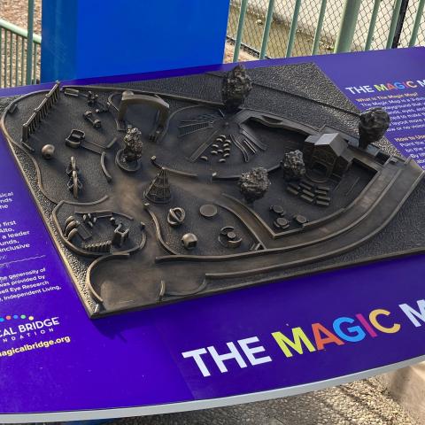 Photo of Magic Map, a bronze scale map of the Magical Bridge Playground in Palo Alto. The bronze map is bordered by panels on both sides with descriptions of the map.