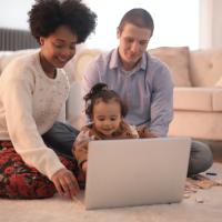 Man, woman, and child looking at a laptop