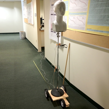 Picture of artificial head, fitted with microphones, on a moving platform