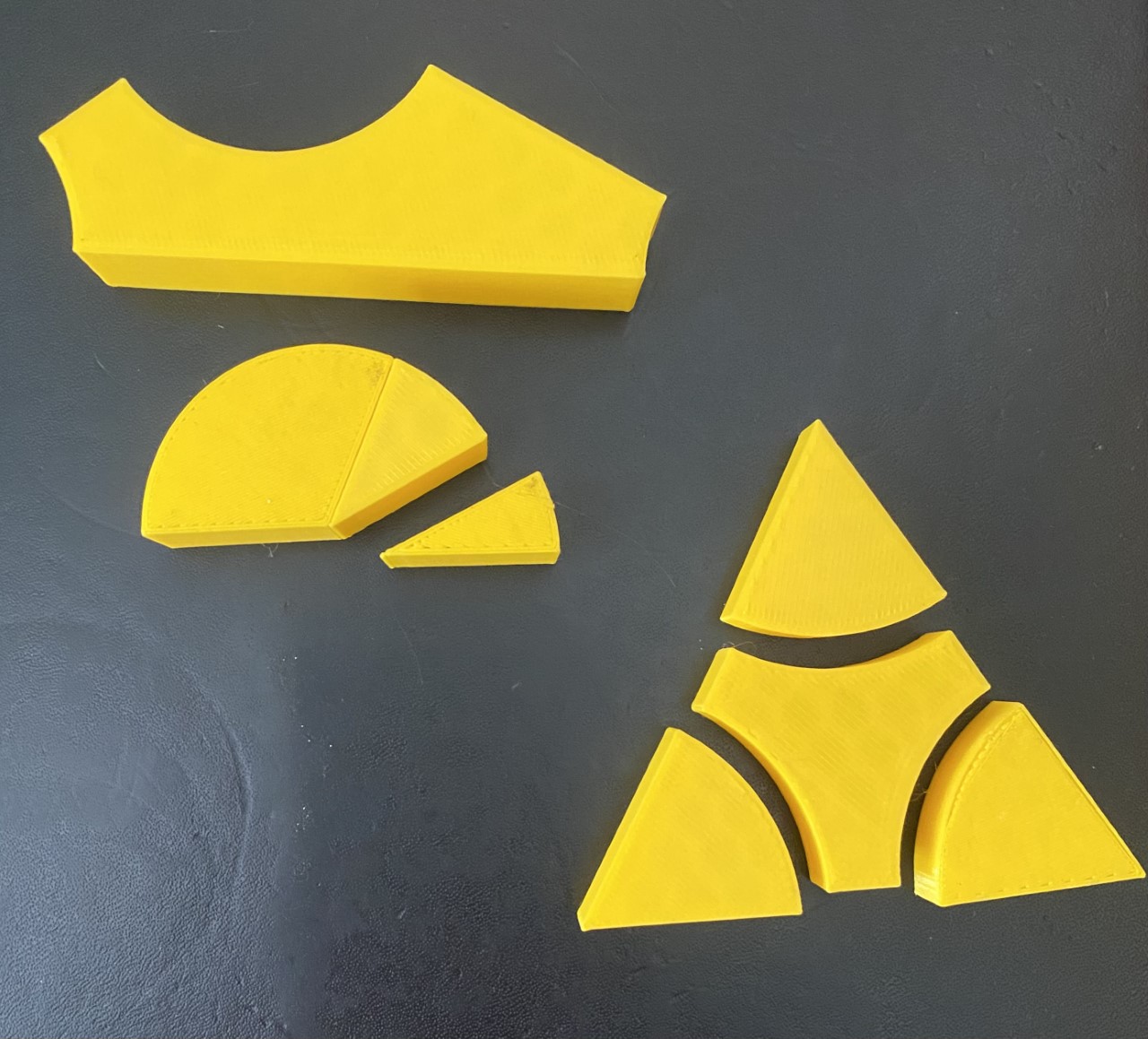 Two printed yellow triangles. The angles are removable and can be placed in a 180 deg half circle.