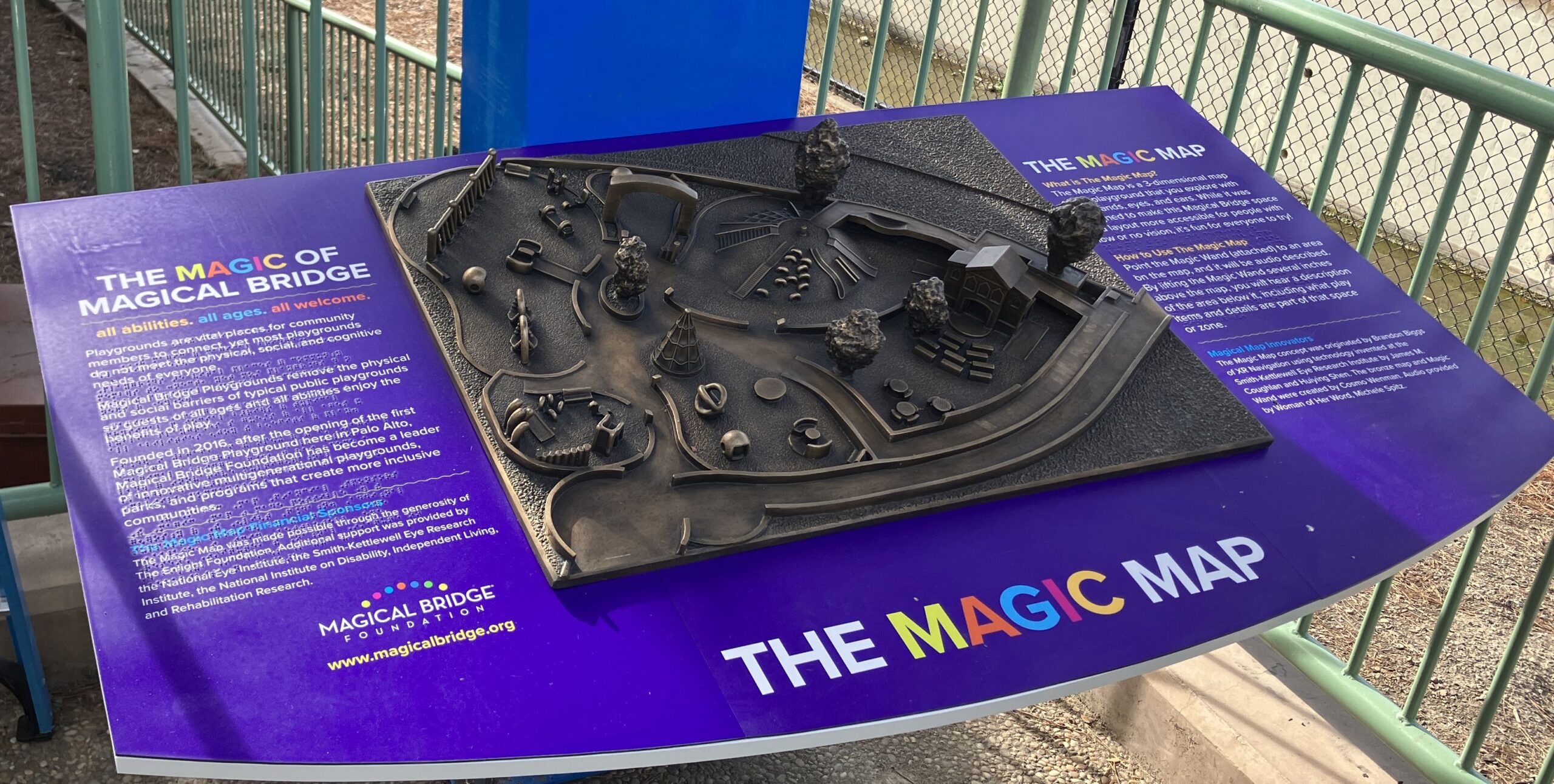 Photo of Magic Map, a bronze scale map of the Magical Bridge Playground in Palo Alto. The bronze map is bordered by panels on both sides with descriptions of the map.