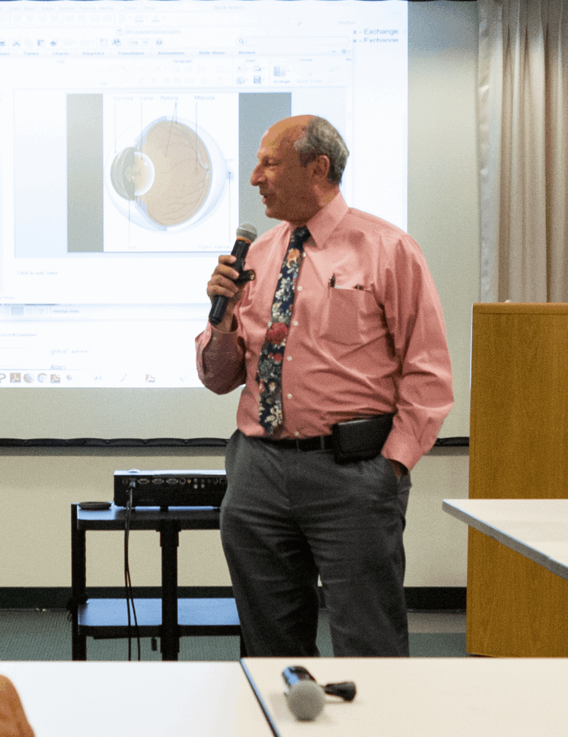 Dr. Fletcher speaking in front of a screen