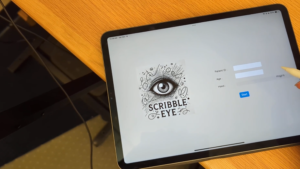 iPad on a desk showing the ScribbleEyes App with an Apple Pencil in the corner.