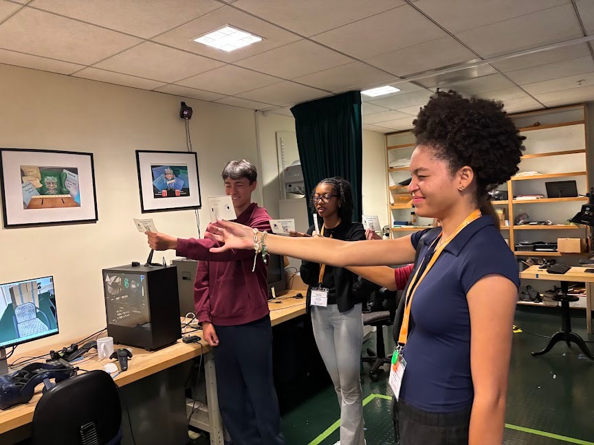 A student tries assistive technology that reads the value of U.S. currency aloud.