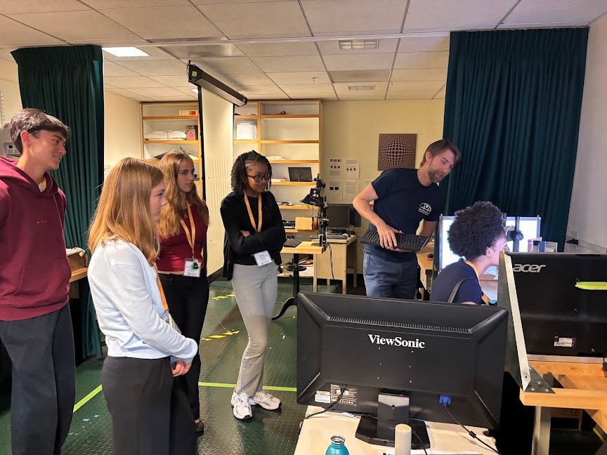 Vision scientist Adrien Chopin shows Summer Springboard students an eye- and head-tracking setup at Smith-Kettlewell.
