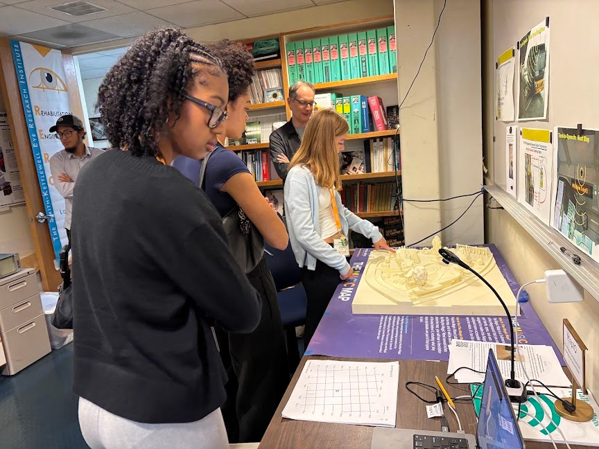 Students trace a 3D-printed tactile map used for wayfinding without sight, with scientist James Coughlan.